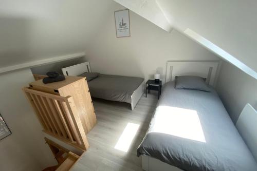 a attic bedroom with two beds and a staircase at Clos Briard - Calme & paisible près Disney & Paris in La Houssaye-en-Brie