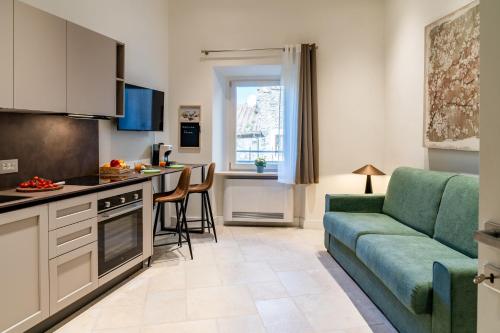 a kitchen and a living room with a couch and a table at Le Finestre su Villa d'Este in Tivoli