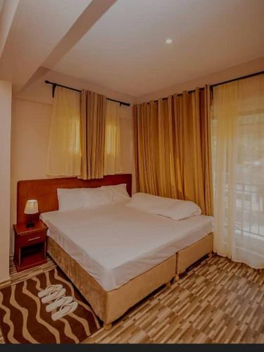 a bedroom with a large bed and a night stand at River point inn in Arusha