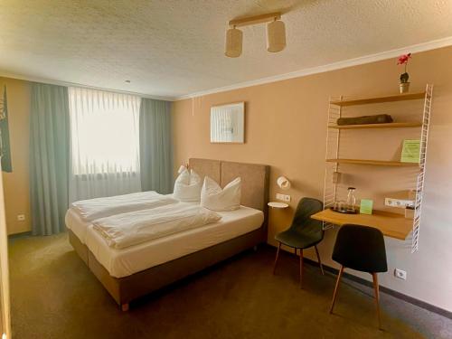 a bedroom with a bed and a desk with chairs at Kocks Hotel Garni in Hamburg
