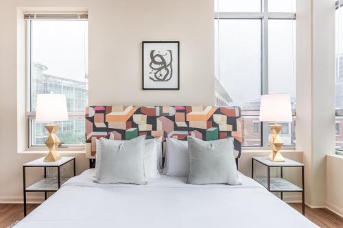 a bedroom with a large white bed with two lamps at Mint House Greenville Downtown By Kasa in Greenville