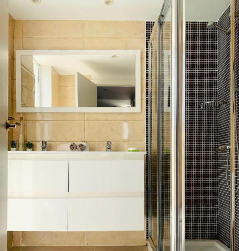 a bathroom with a sink and a shower with a mirror at Amazing duplex Las Americas in Costa de Adeje