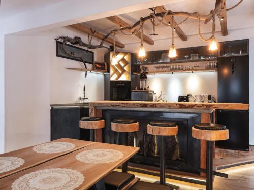 a kitchen with a bar with wooden stools at Luxury Larch Loft in Tesido