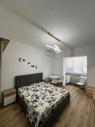 a bedroom with a bed and a table with chairs at E&B Cosy Apartment 6 in Tirana