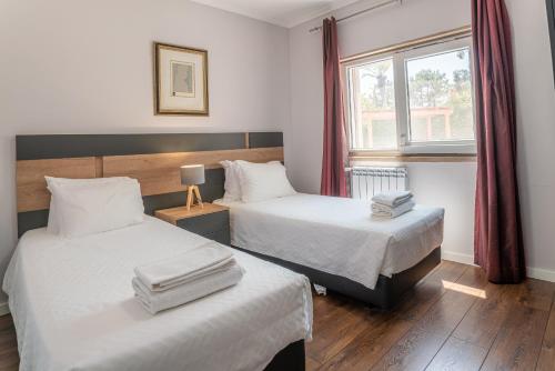 a hotel room with two beds and a window at Villa Atlantica in Setúbal