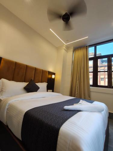 a bedroom with a large bed with a ceiling fan at Hotel Regal Gate in Mumbai