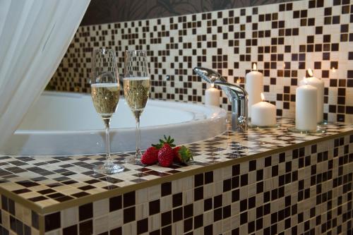 a bathroom with two glasses of champagne and strawberries at Wellness hotel Spark in Malacky