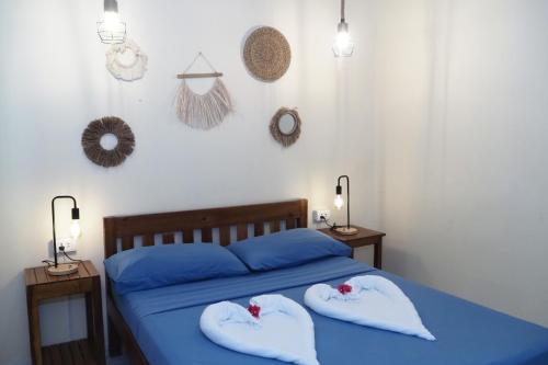 a bedroom with a blue bed with two pillows at Azuls Tourist Inn in San Vicente