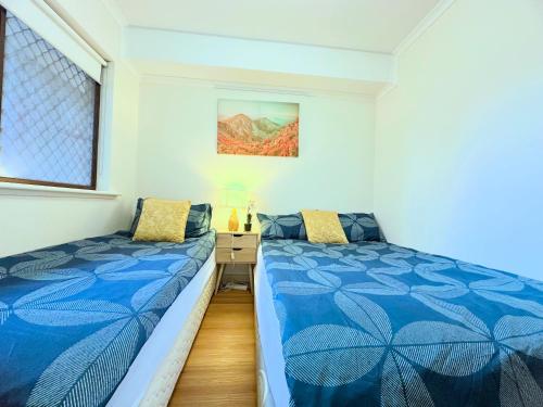 a bedroom with two beds and a window at Deluxe Himeji 2 Bedrooms Apartment in Adelaide