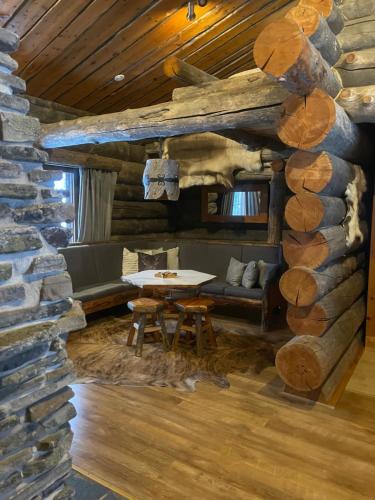 a living room with a table and a stone wall at Kelogornitsa - Levikeskus 2 km - ski bus 300 m in Kittilä