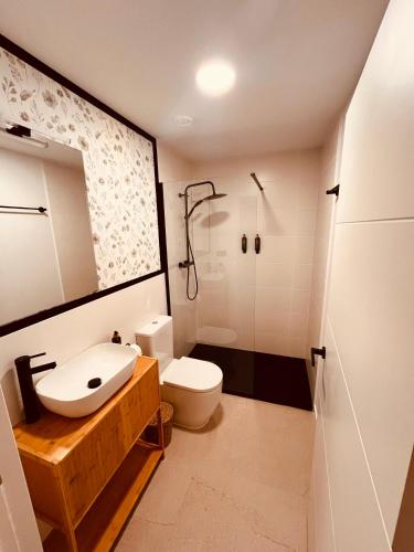 a bathroom with a toilet and a sink and a shower at Casa Kirana - Habitaciones in Bermeo