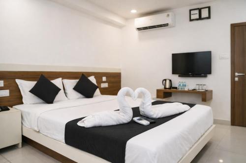 a hotel room with two beds with swan towels at Stay Prime, Balewadi in Pune