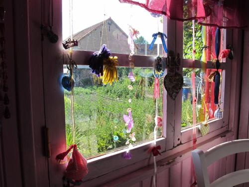 a window with a view of a yard at La Roulotte De Lola - Chambre d'hôtes in La Celle