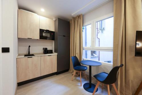 a kitchen with blue chairs and a table in a room at Password to Malasaña in Madrid