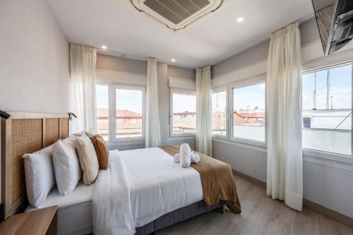 a bedroom with a large bed with windows at Password to Malasaña in Madrid