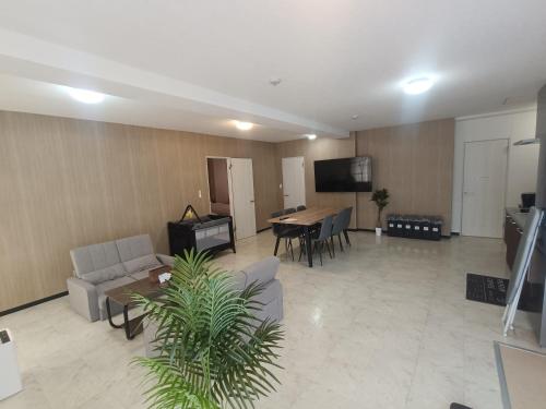 a living room with a couch and a table at -Ina Stay Central Hotel-8名宿泊可 伊那市駅徒歩5分 駐車場無料 a sleep8-a 5minute walk from the station-Free parking in Ina