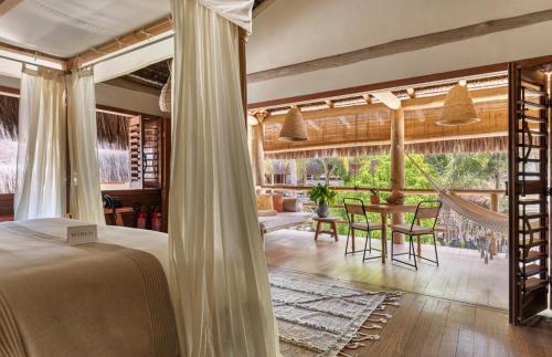 a bedroom with a bed and a table and chairs at Sempre Vivo in Pipa