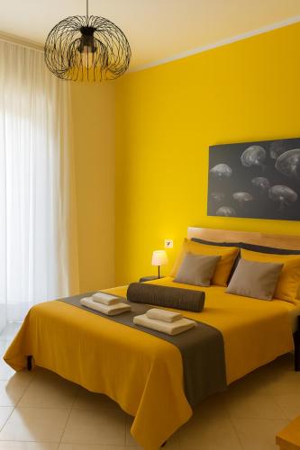a yellow bedroom with a large bed with yellow walls at B&B D'Aponte Home Napoli Est Parcheggio Gratuito in Volla