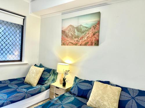 a room with two beds and a picture on the wall at Deluxe Himeji 2 Bedrooms Apartment in Adelaide