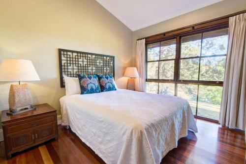 a bedroom with a bed and a large window at Friday Creek Retreat in Coffs Harbour