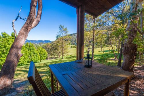 a wooden table in a tree house with a view at Friday Creek Retreat in Coffs Harbour