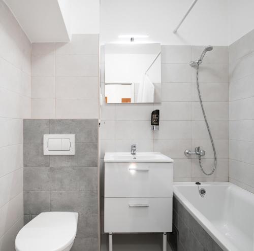 a bathroom with a sink and a toilet and a tub at Hotel Veronika in Ostrava