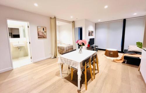 a living room with a table with flowers on it at High Rise CBD Apartment with Amazing Views, 3 beds, Gym,SPA & Pool, Easy Transport in Melbourne