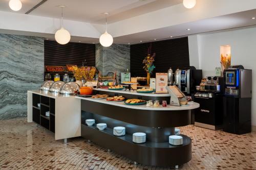 a buffet line with food on display in a restaurant at HF Fénix Garden in Lisbon