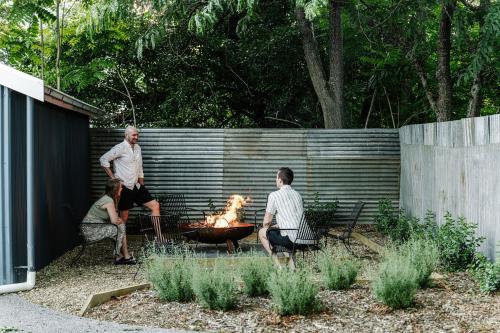 a group of people sitting around a fire pit in a yard at Corner Cottage Bright in Bright