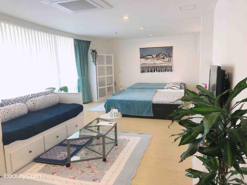 a bedroom with a bed and a couch in it at Maison Lumière in Odawara
