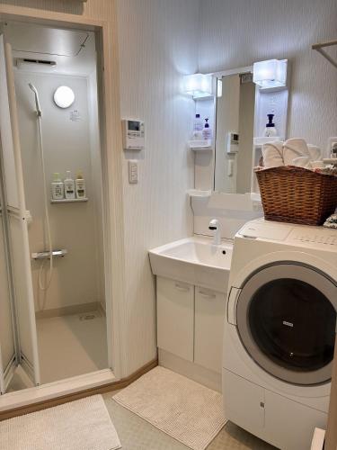 a bathroom with a washing machine and a sink at Maison Lumière in Odawara