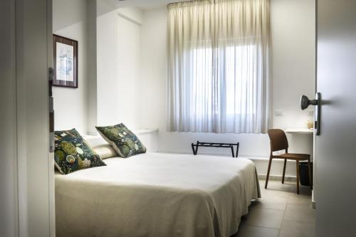 a bedroom with a bed and a desk and a window at Ciauru al Sud in Messina