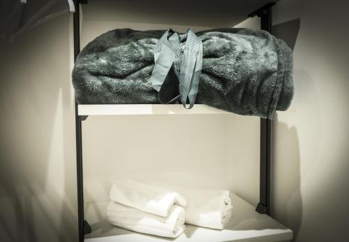 a shelf with towels and a coat on it at Ciauru al Sud in Messina