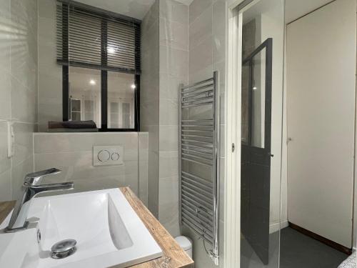 a white bathroom with a sink and a shower at Lyon Standing Historic City Apartment in Lyon