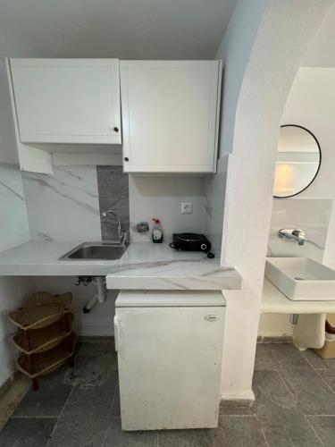a kitchen with white cabinets and a sink at Sea View Studios & Apartments in Agia Anna Naxos
