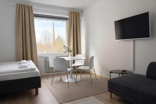 a hotel room with a bed and a table and chairs at Tammer Huoneistot - City Suite 2 - City View & Perfect location in Tampere