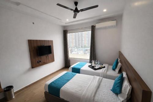 a hotel room with two beds and a window at Hotel Global Inn Gold in Lucknow