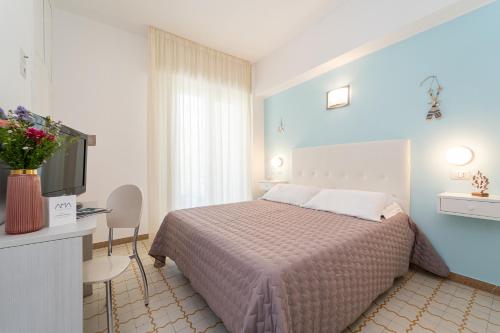 a bedroom with a bed and a tv in a room at Amadei Hotel Promenade in Pesaro