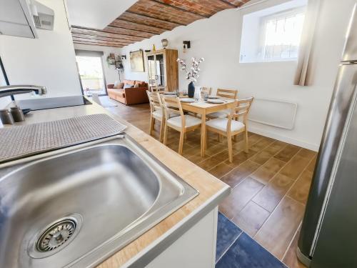 a kitchen with a sink and a table with chairs at Appartement Confortable à Coulommiers avec Jardin in Coulommiers