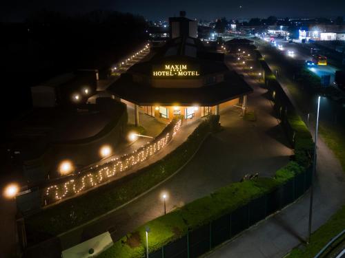 a view of a hotel at night with lights at Hotel Maxim in Peschiera Borromeo