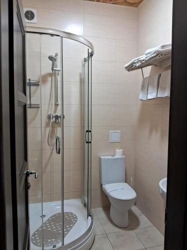 a bathroom with a toilet and a glass shower at BavariaHotel in Kharkiv