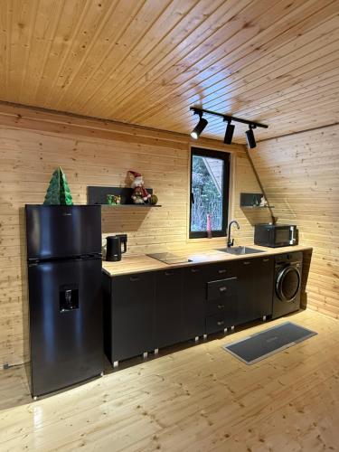a kitchen with a black refrigerator and a sink at "Panorama" Kakhri in Mestia