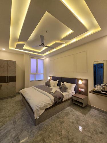 a bedroom with a large bed and a ceiling with lights at Hotel Vatsalya by The Holy Meander in Varanasi