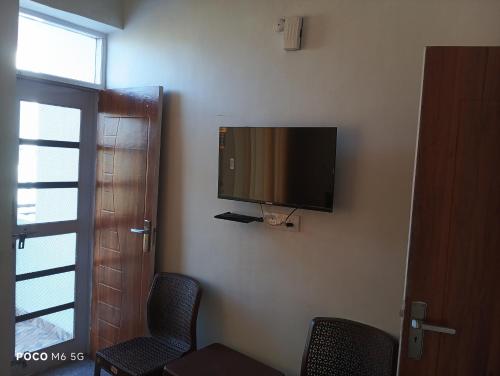 a flat screen tv on the corner of a room at Dhananjay home stay in Dharampur