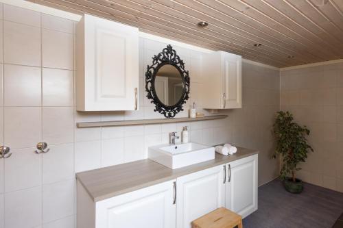 a white bathroom with a sink and a mirror at Skoglund privat Villa in Trysil