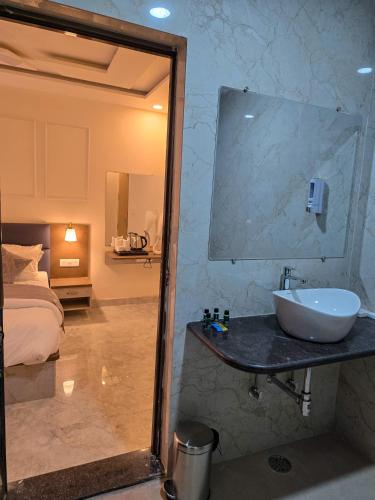 a bathroom with a sink and a bed at Hotel Vatsalya by The Holy Meander in Varanasi