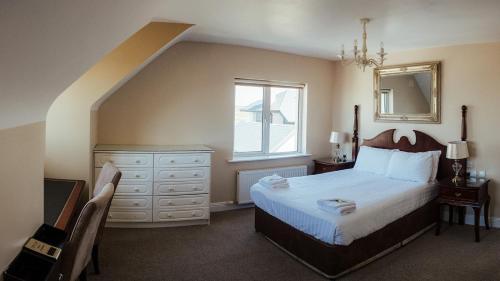 a bedroom with a bed and a dresser and a window at Lehinch Lodge in Lahinch