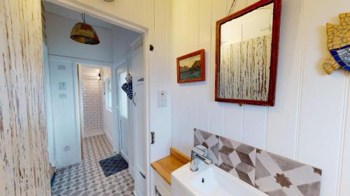 a bathroom with a sink and a mirror on the wall at E41 Silver Mist, Riviere Towans in Hayle