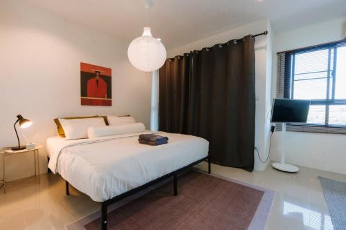 a bedroom with a large bed and a television at Kawish House กาวิส เฮ้าส์ in Ban Hua Trut