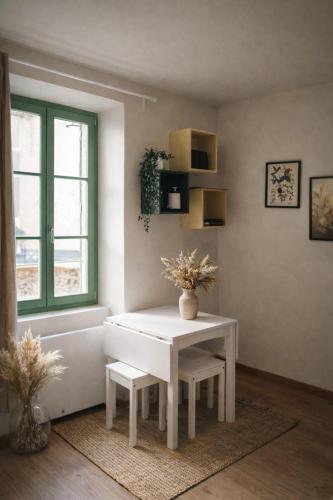 a white table and chairs in a room with a window at Studio neuf équipé, confortable et au calme in Issoire